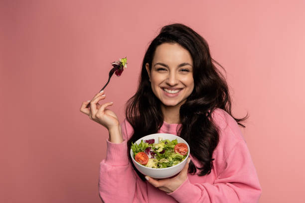 Woman smiling and eating salad