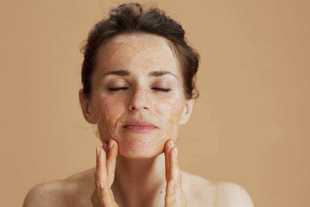 Woman applying facial scrub for skincare routine