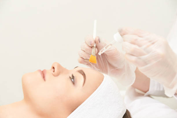 Esthetician applying facial treatment to female client